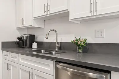a kitchen with white cabinets and a stainless steel sink at East Village Arts District, King Suite with Sofa Bed NRP23-01221 in Long Beach