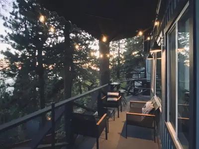 a balcony with benches and lights on a house at The Inspo Cabin with Stunning View in Running Springs