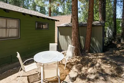 a table and chairs in front of a green house at Village and Lake Escape - Walk to the Lake and Village in Big Bear Lake