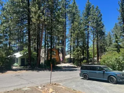 a blue suv parked in a driveway in front of a house at Village and Lake Escape - Walk to the Lake and Village in Big Bear Lake