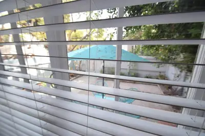a window with white blinds looking out at a table at Villa by the Ocean in Venice Beach in Los Angeles