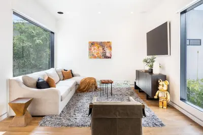 a living room with a couch and a tv at The Palms Pad - 5 Min from Beach - Golf,Arcade,Sauna in Los Angeles