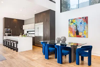 a kitchen with a dining table and blue chairs at The Palms Pad - 5 Min from Beach - Golf,Arcade,Sauna in Los Angeles
