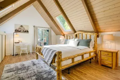 a bedroom with a wooden bed in a attic at Steps to Lake Arrowhead Cabin with Full Lake Access in Lake Arrowhead