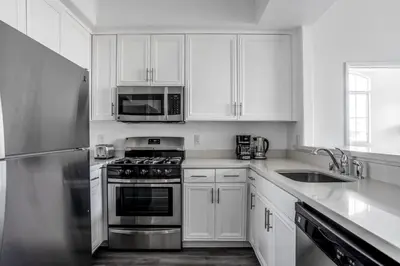 a kitchen with white cabinets and stainless steel appliances at West LA 2br w rooftop courtyard LAX-1055 in Los Angeles