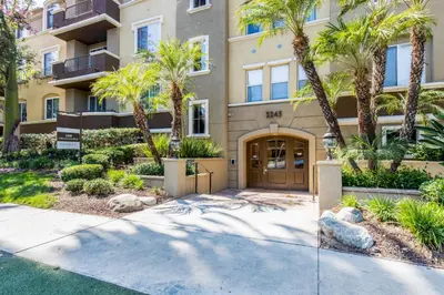 a apartment building with palm trees and a door at West LA 2br w rooftop courtyard LAX-1055 in Los Angeles
