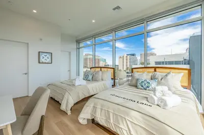 two beds in a room with a large window at @ Marbella Lane - Sleek Corner Ocean View in Long Beach