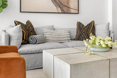 a living room with a gray couch with pillows at #Marbella Lane - Panoramic Splendid Ocean Views! in Long Beach
