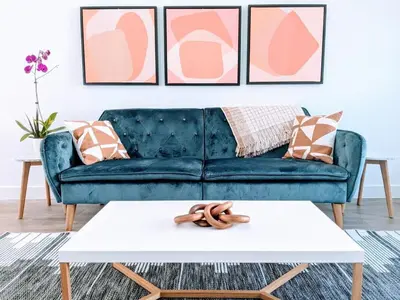 a blue couch in a living room with pink andige pillows at Downtown Culver City New Designer Lux 1 Bedroom in Los Angeles