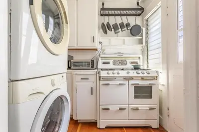 a kitchen with a stove and a washer and dryer at Hermosa Bungalow 1920s Charm Steps to the Strand in Hermosa Beach