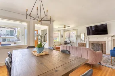 a dining room with a wooden table and a fireplace at Hermosa Bungalow 1920s Charm Steps to the Strand in Hermosa Beach