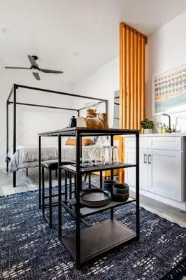 a black shelf in a room with a kitchen at Vibe on the Patio at a Modern Luxury Studio near LAX Beach in Los Angeles