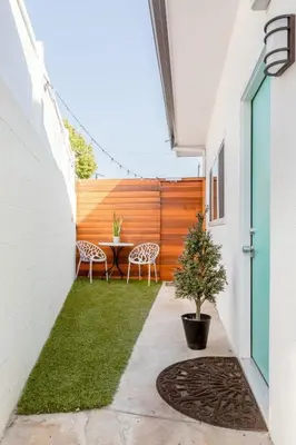 a courtyard with a table and chairs and a fence at Vibe on the Patio at a Modern Luxury Studio near LAX Beach in Los Angeles