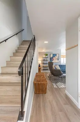 a living room with stairs and a chair at Downtown Manhattan Beach 3 Bed Townhouse Parking in Manhattan Beach