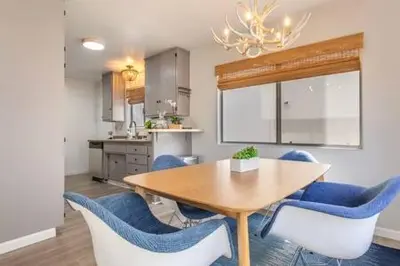 a dining room with a table and blue chairs at Downtown Manhattan Beach 3 Bed Townhouse Parking in Manhattan Beach