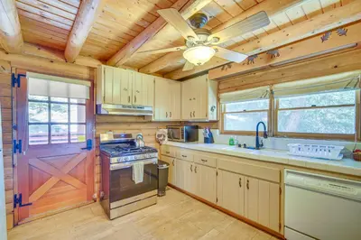 a kitchen with a stove and a ceiling fan at Crestline Area Vacation Rental Cabin with Decks! in Crestline