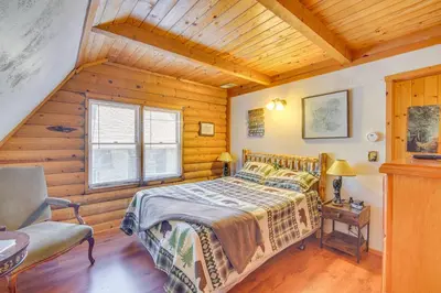 a bedroom with a bed and a chair in a room at Crestline Area Vacation Rental Cabin with Decks! in Crestline