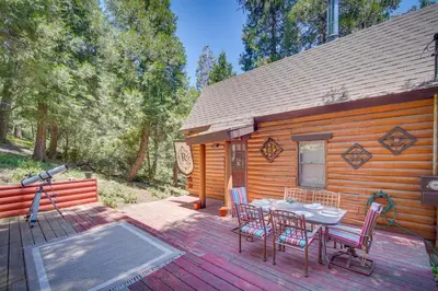 a wooden cabin with a table and chairs on a deck at Crestline Area Vacation Rental Cabin with Decks! in Crestline