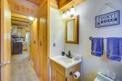 a bathroom with a sink and a mirror in a cabin at Crestline Area Vacation Rental Cabin with Decks! in Crestline