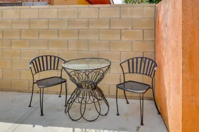 three chairs and a glass table in front of a brick wall at Sleek San Fernando Studio about 14 Mi to Universal in San Fernando