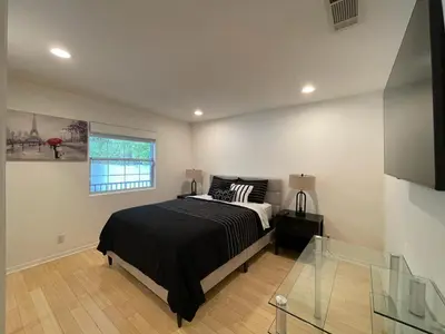 a bedroom with a black bed and a window at Charming Bright Traditional Home in Sherman Oaks in Sherman Oaks