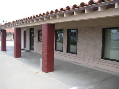 a row of windows on a building with red columns at Americas Best Value Inn - Porterville in Porterville