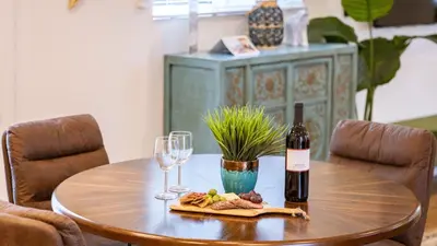 a table with a bottle of wine and two glasses at Urban Jungle by AvantStay in Los Angeles