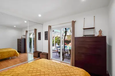 a bedroom with a bed and a sliding glass door at Villa La Verde - Newly Designed 4BR Villa with Pool & Guesthouse by Topanga in Los Angeles