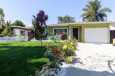 a house with a garage and flowers in the yard at Villa La Verde - Newly Designed 4BR Villa with Pool & Guesthouse by Topanga in Los Angeles