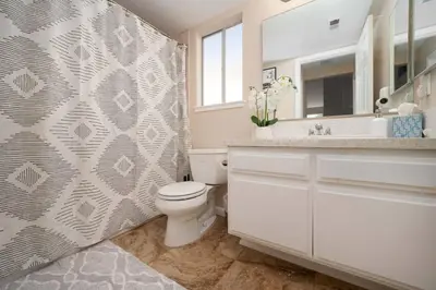 a bathroom with a toilet and a sink and a mirror at Families/Digital Nomads/Corporate Housing in Bakersfield