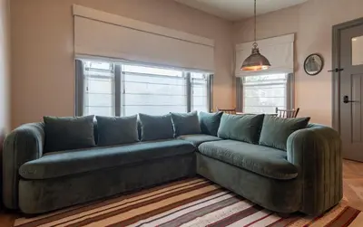 a green couch in a living room with a window at Gjelina Hotel in Los Angeles