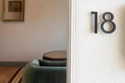 a door with a house number on it next to a couch at Gjelina Hotel in Los Angeles