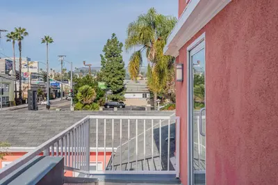 a balcony of a red building with a view of a street at Day Dreams by AvantStay in Los Angeles