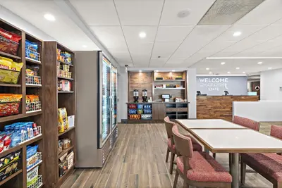 a waiting room with a table and chairs in a store at Hampton Inn Los Angeles Airport in Los Angeles