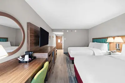 a hotel room with two beds and a mirror at Hampton Inn Los Angeles Airport in Los Angeles