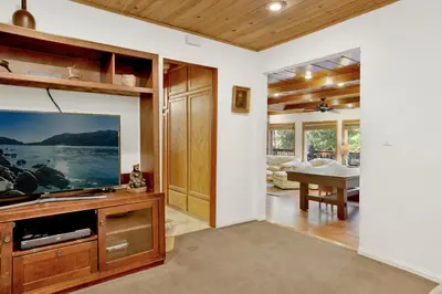 a living room with a flat screen tv and a table at Knickerbocker Retreat- Hot Tub- Game Tables in Big Bear Lake