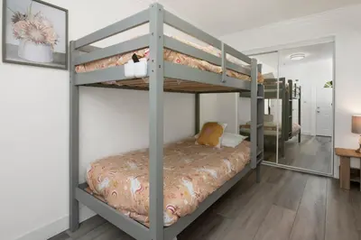 a bedroom with two bunk beds with a mirror at Sweet Retreat 2- Cozy Relaxing Resort Cottage in Big Bear Lake