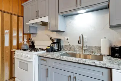 a kitchen with white cabinets and a sink at Sweet Retreat Combo- Relaxing Resort Cottage Combo in Big Bear Lake