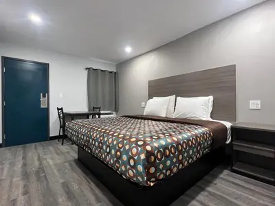 a bedroom with a large bed and a blue door at Vance Motel in Lynwood