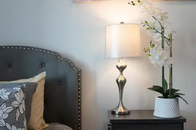 a bedside table with a lamp and a vase of flowers at Comfy Apt with pool & hot tub in downtown LA 658 in Los Angeles