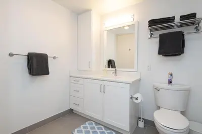 a bathroom with a toilet and a sink and a mirror at Comfy Apt with pool & hot tub in downtown LA 658 in Los Angeles