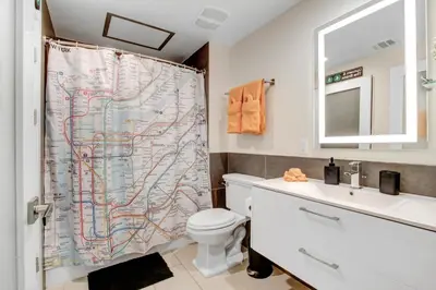 a bathroom with a map shower curtain with a toilet and sink at NYC Styled Loft In DTLA, sleeps 4 with Free Parking! in Los Angeles