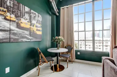 a table in a room with a green wall at NYC Styled Loft In DTLA, sleeps 4 with Free Parking! in Los Angeles