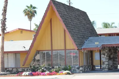 a yellow building with a black roof at Cinderella Motel in Wasco