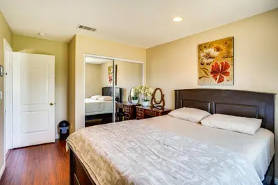 a bedroom with a large bed and a mirror at Westminster Apartment Near Beaches and Theme Parks! in Westminster