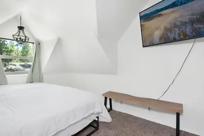 a bedroom with a bed and a table and a window at Maltby Modern Log Cabin Relaxing Chalet Retreat in Big Bear Lake