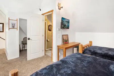 a bedroom with two beds and a table and a door at Maltby Modern Log Cabin Relaxing Chalet Retreat in Big Bear Lake