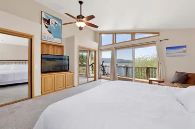 a bedroom with a white bed and a large window at Lakefront Village Castle- Foosball- Boat Dock- in Big Bear Lake