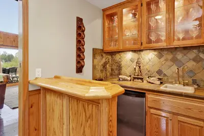 a kitchen with wooden cabinets and a sink at Lakefront Village Castle- Foosball- Boat Dock- in Big Bear Lake