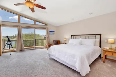 a bedroom with a bed and a large window at Lakefront Village Castle- Foosball- Boat Dock- in Big Bear Lake